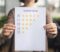 Satisfaction concept. Woman choosing with tick five star rating on paper sheet, blurred background