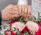 The hands of the bride and groom with rings on the background of a wedding bouquet of roses. The concept of marriage.